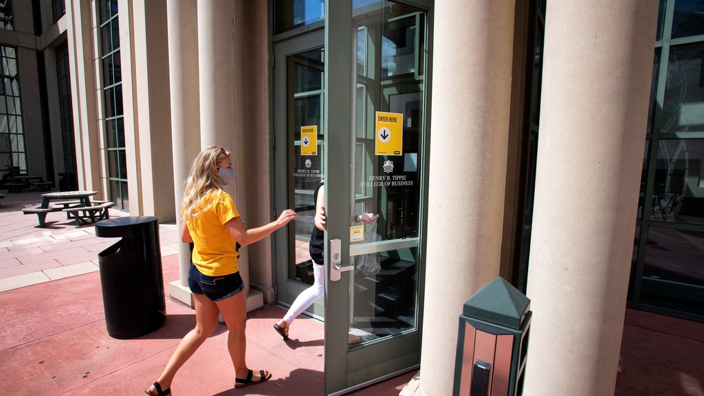 Student wearing PPE entering Pappajohn Business Building